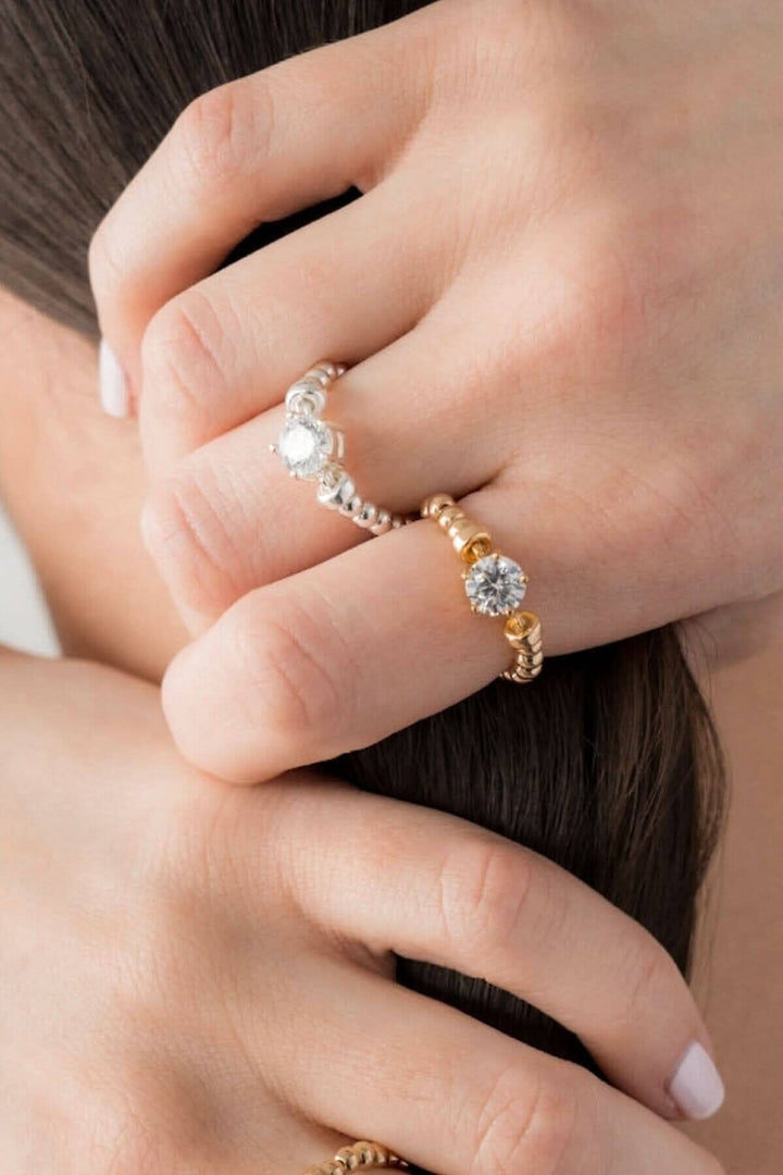 Bague élastique Be Treasured en argent et or, ornée de zirconiums colorés, portée avec élégance.