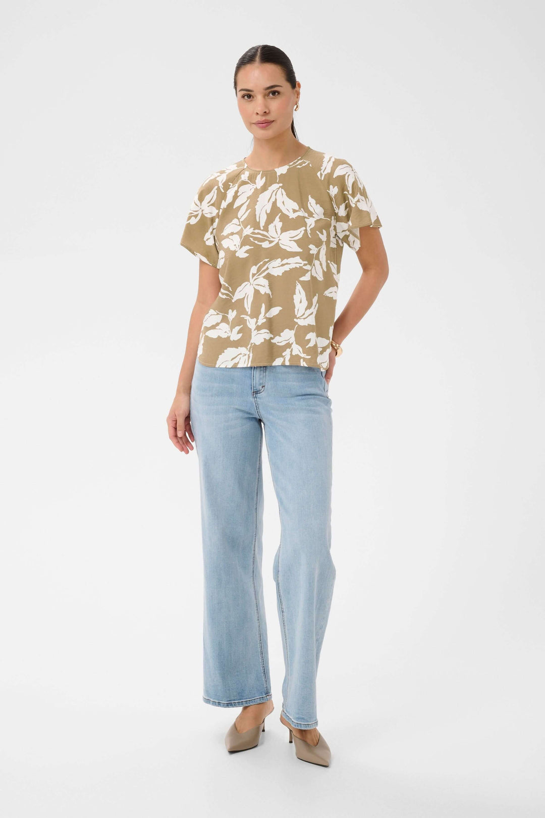 Femme portant la Blouse Marlo fluide à imprimé feuillage avec manches courtes, parfait pour un look estival élégant et confortable.