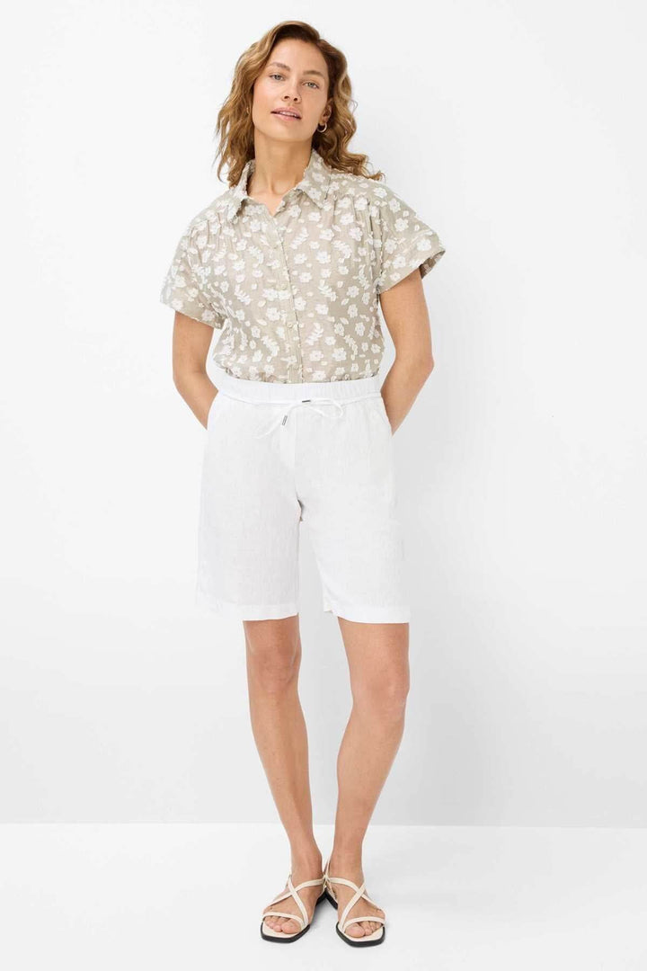 Femme portant une blouse à motifs floraux légers et un short blanc, parfait pour l&