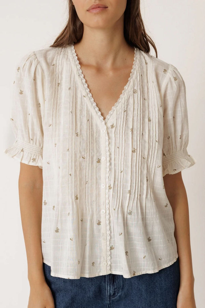 Blouse à encolure dentelle avec manches bouffantes courtes et imprimé discret, idéale pour un look féminin et délicat.