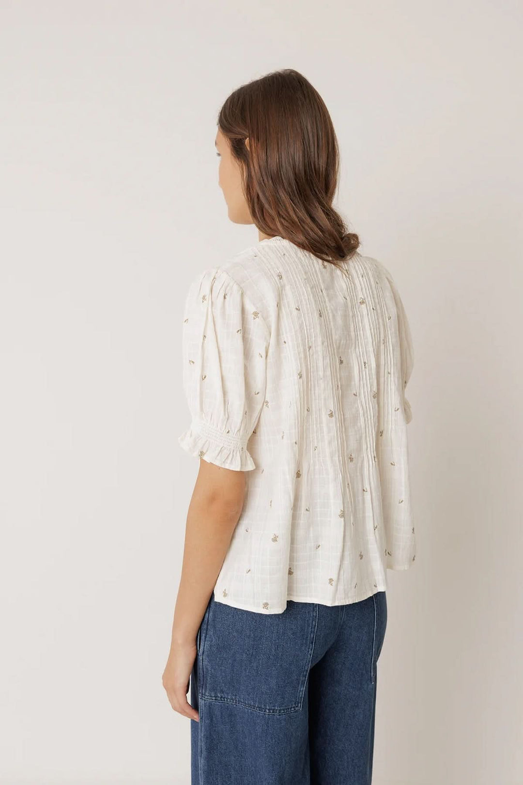 Blouse à encolure dentelle avec manches courtes bouffantes et plis verticaux, vue arrière, texture légère et imprimé discret.