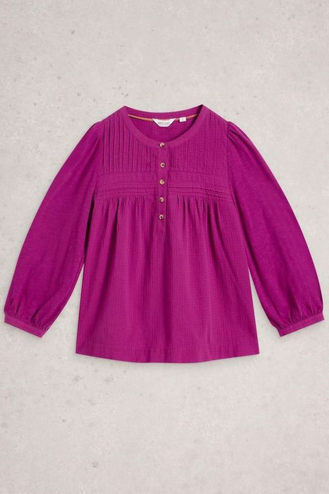 Blouse plumetis à plastron froncé en tissu fluide, couleur vive, manches longues, idéal pour un style féminin et élégant, rentré dans un jean.