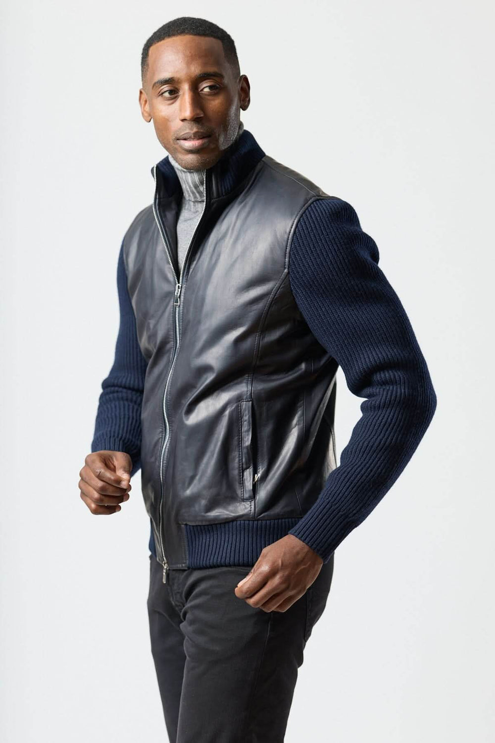 Blouson hybride cuir & tricot zippé moderne porté par un homme élégant avec col roulé, offrant confort et style urbain.