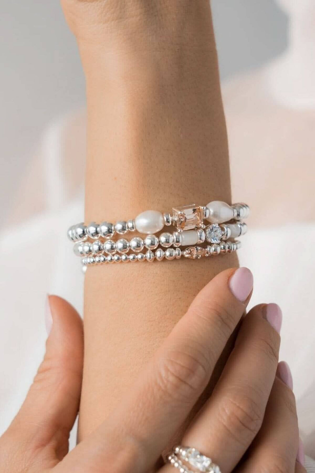 Bracelet en argent Be Iconic avec perles et breloques en zirconium, ajoutant élégance et lumière au poignet.
