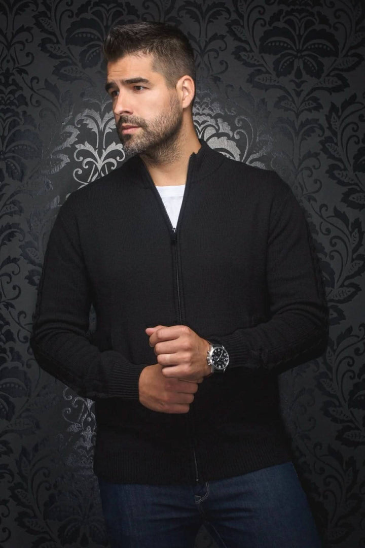 Chandail noir en laine Esteban, homme stylé avec fermeture éclair, contre un fond décoratif.