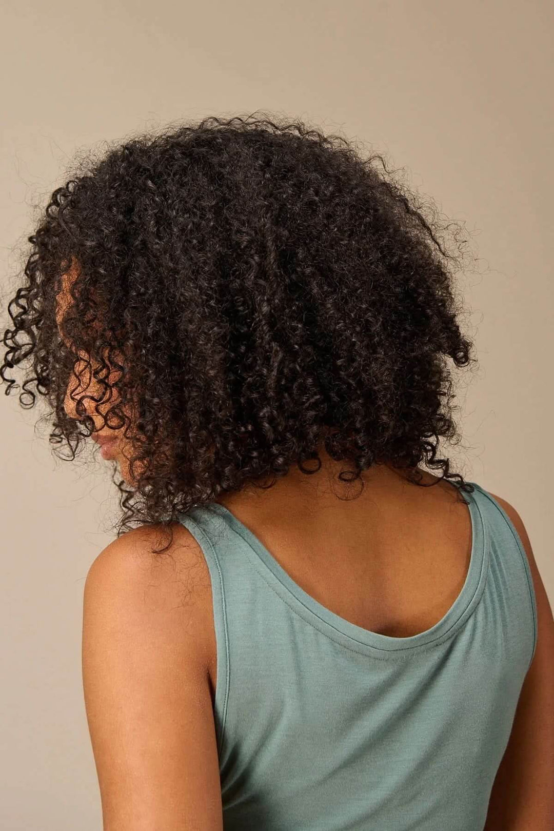 Modèle portant une camisole à col rond avec bretelles larges, vue de dos, montrant la coupe ajustée et le confort de la tenue.