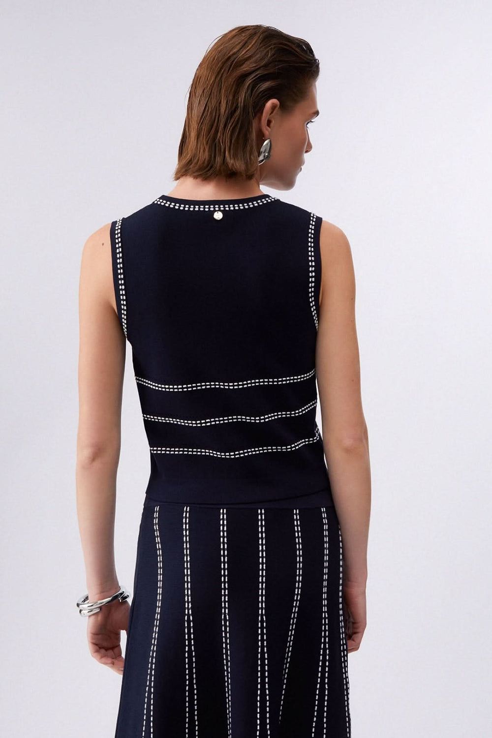 Vue arrière de la camisole en maille sans manches à motif rayé, montrant le design élégant et structuré. Idéale pour un look moderne.