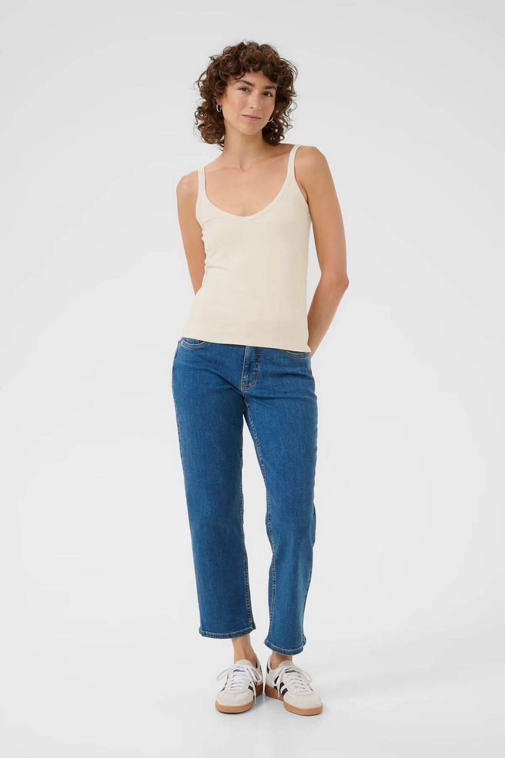 Femme portant une camisole à encolure arrondie avec lignes épurées et coupe ajustée, idéale pour le confort et l'élégance.