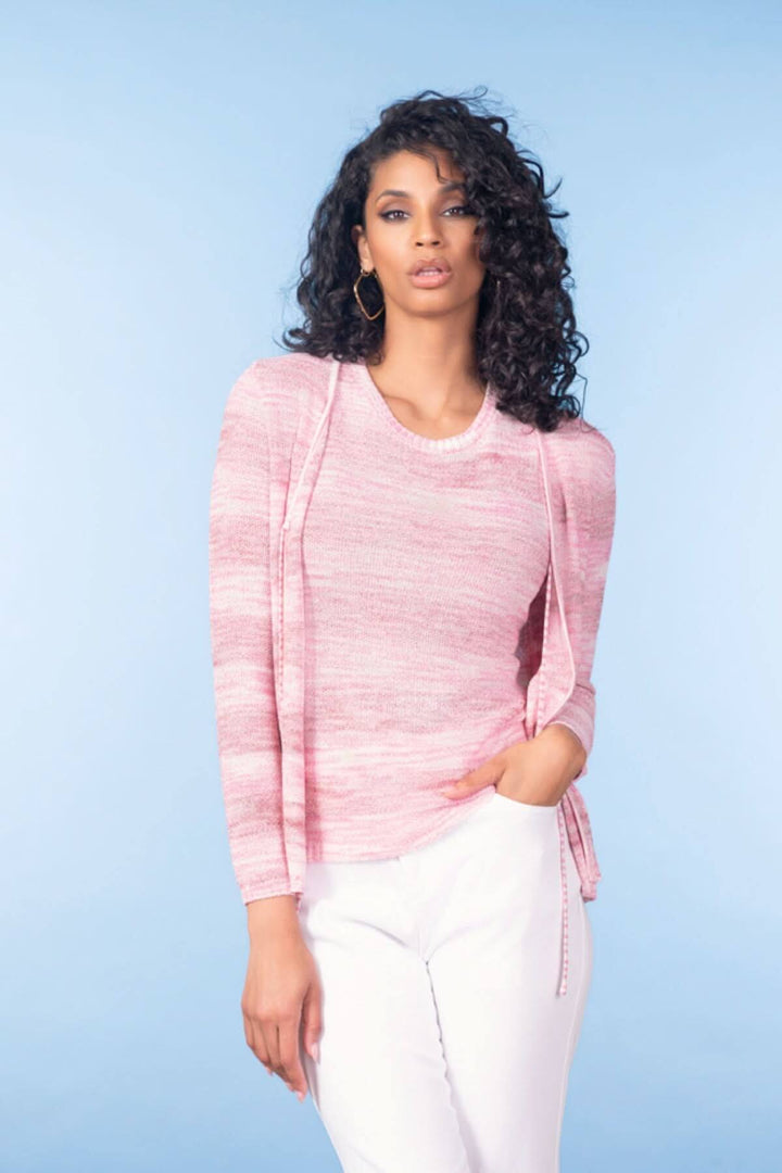 Femme portant une camisole texturée rose avec une coupe ajustée et une encolure arrondie, sur fond bleu clair.