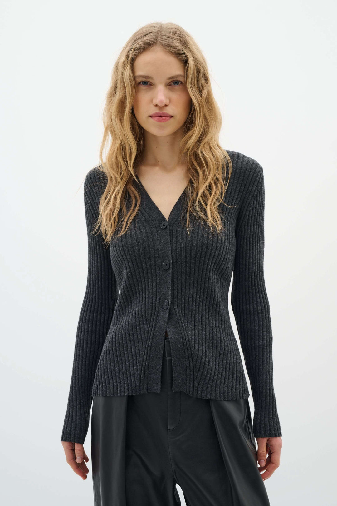 Femme portant le Cardigan Gia en maille côtelée avec encolure en V et boutons, style élégant et féminin.
