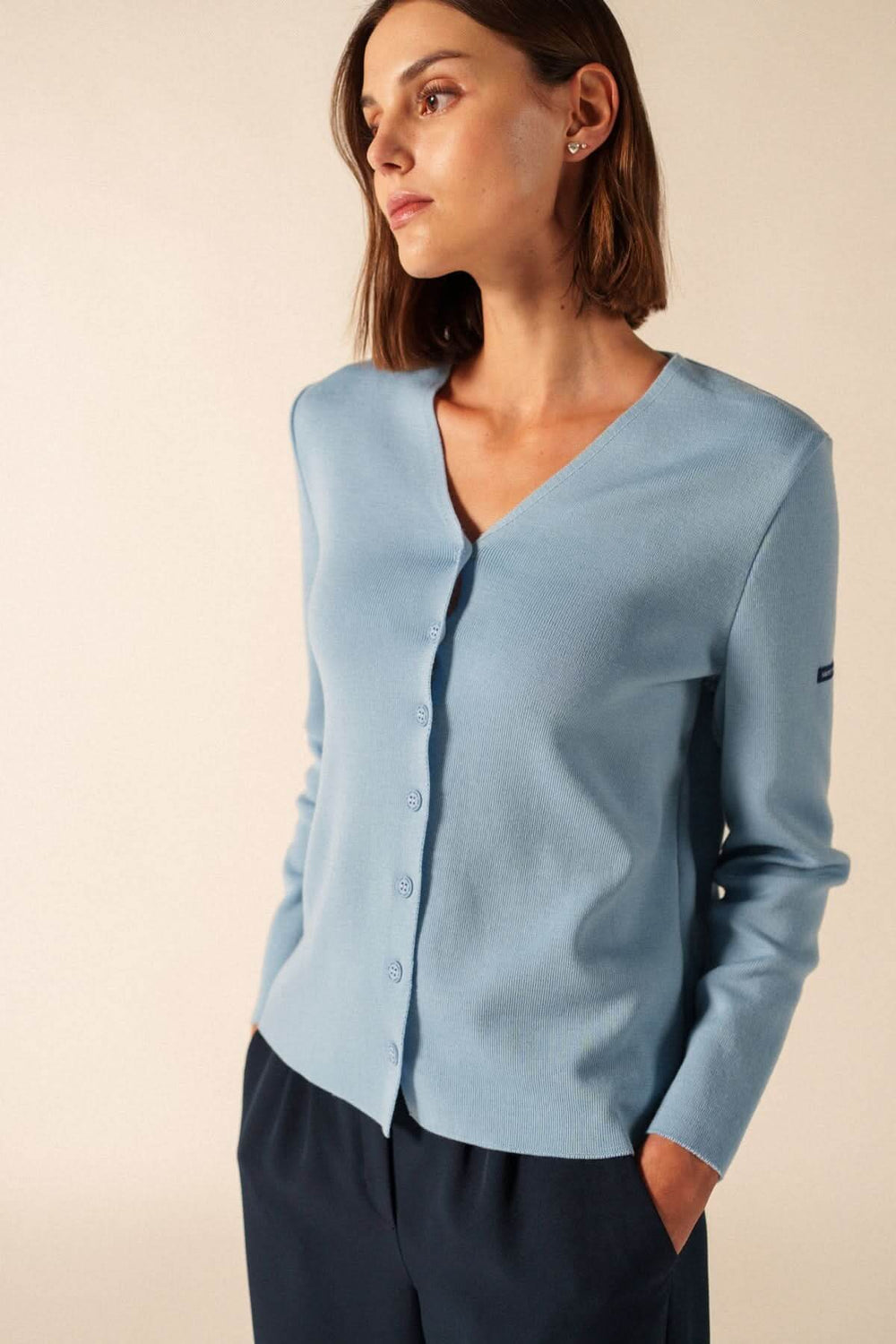 Modèle portant le Cardigan de laine BREVANDS en bleu ciel avec encolure en V et boutons discrets, style élégant et polyvalent.