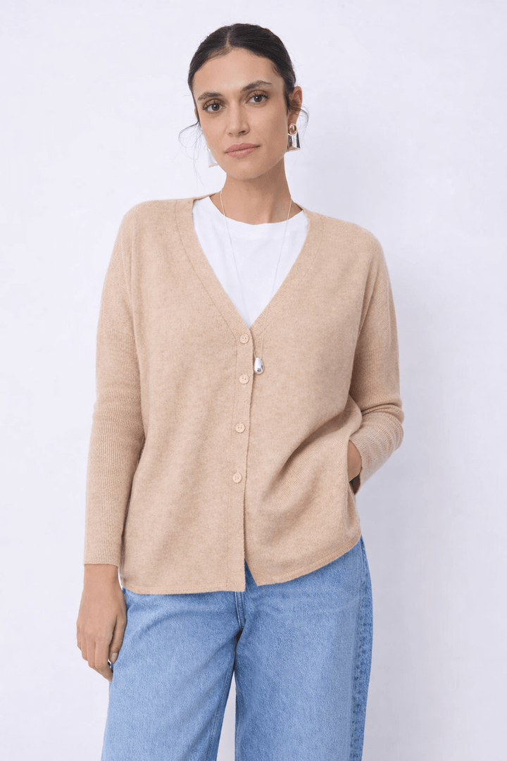 Femme portant le Cardigan en cachemire Alicia couleur neutre avec encolure en V et fermeture boutonnée, look épuré et confortable.
