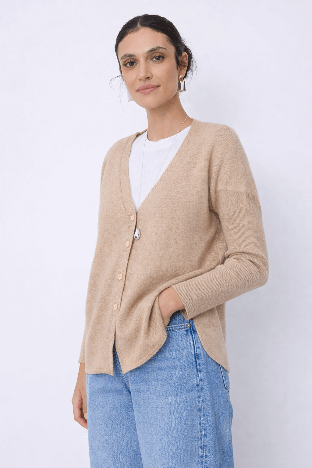 Femme portant le Cardigan en cachemire Alicia, coupe droite avec encolure en V, couleur beige, pour une tenue quotidienne élégante.