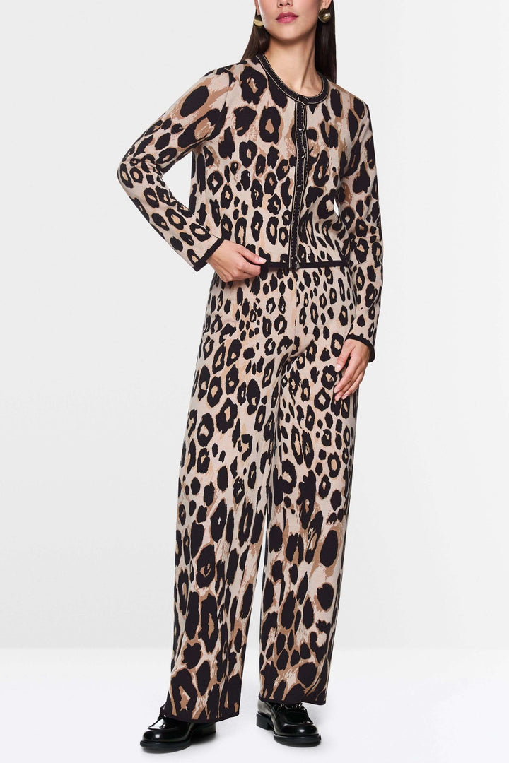 Cardigan léopard à motif animal audacieux porté avec ensemble coordonné, coupe droite élégante et finitions contrastées.