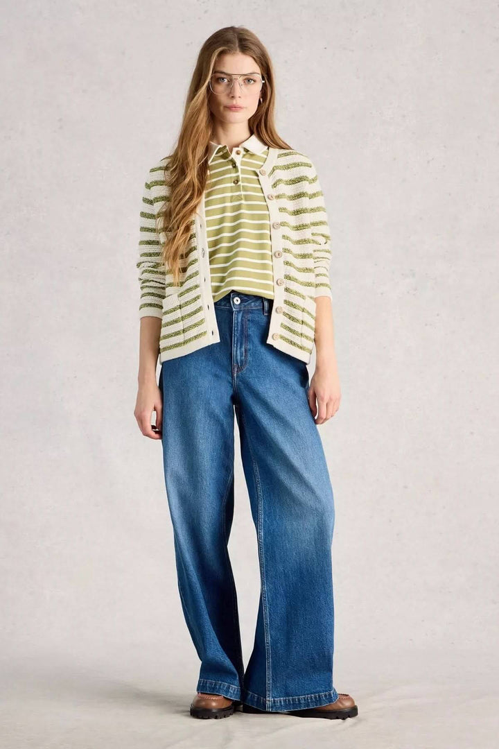 Femme portant un cardigan rayé boutonné vert et blanc avec jeans larges, idéal pour un look décontracté au quotidien.
