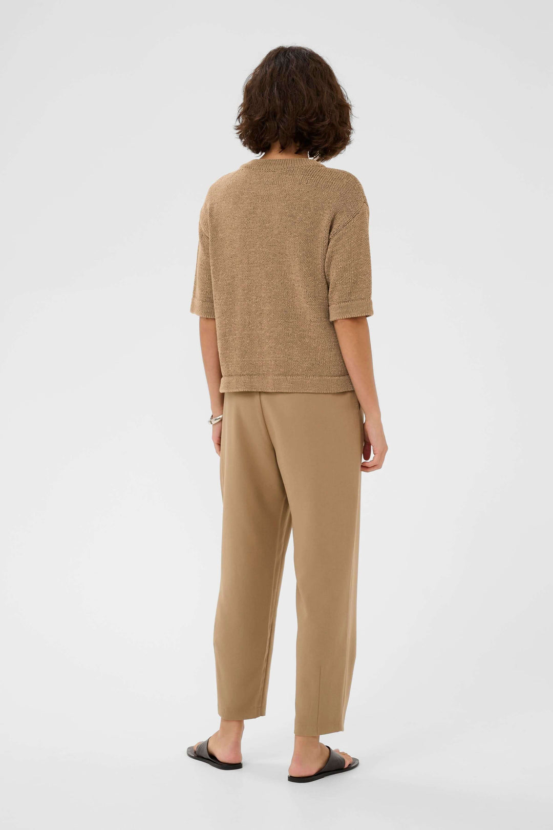 Femme portant le Chandail Sevita en maille fine pour un style décontracté et contemporain avec coupe droite et manches courtes.