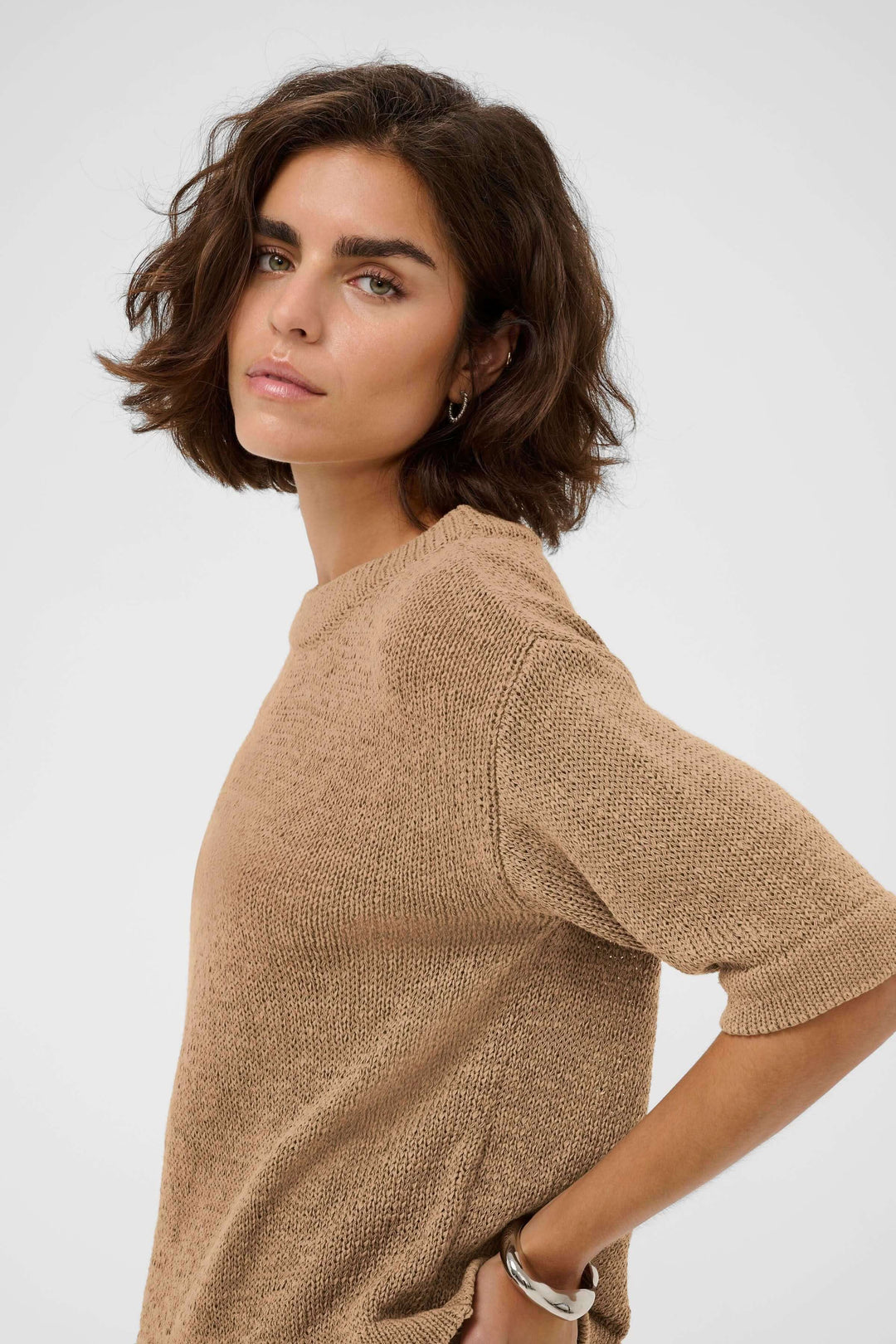 Femme portant le Chandail Sevita en maille légère avec coupe droite et manches courtes pour un style décontracté et moderne.