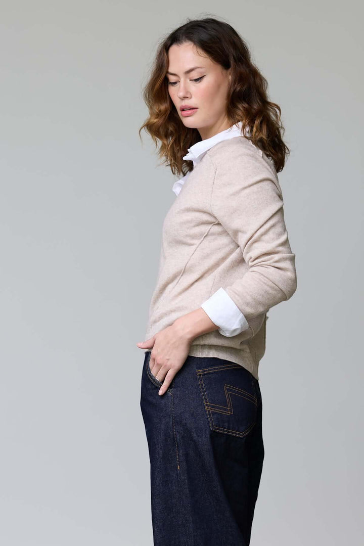 Femme portant un chandail col en V classique, élégamment superposé, avec des détails côtelés parfaits pour un style raffiné.