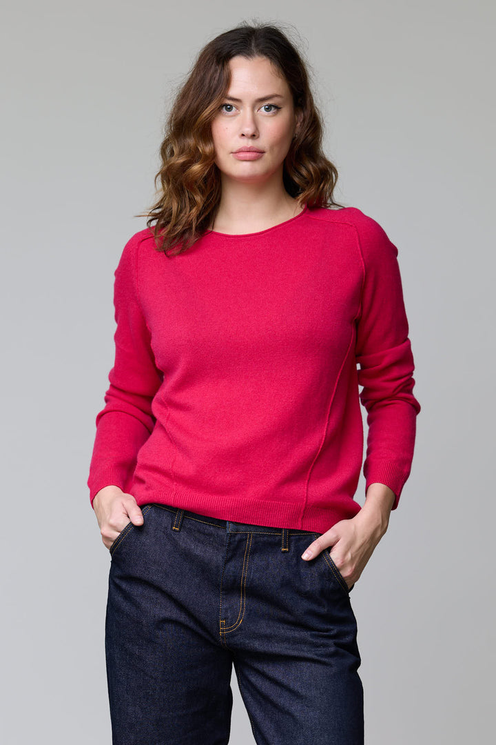 Femme portant un chandail à col rond rouge, manches longues, coupe classique, avec jean, pour un style décontracté et élégant.