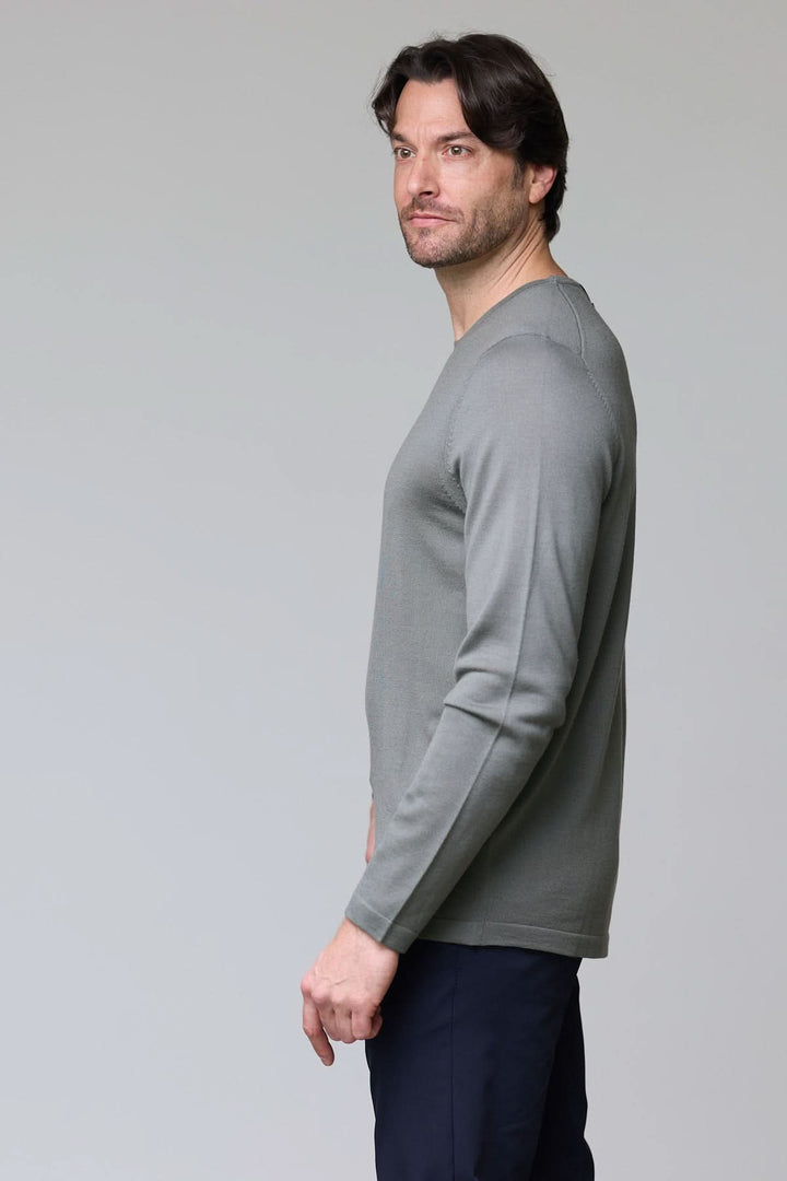 Homme portant un chandail col rond en tricot fin gris, vue latérale.