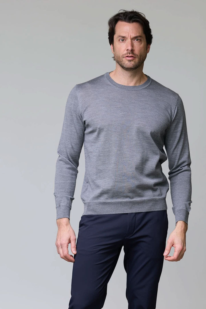 Homme portant un chandail col roulé en laine mérinos gris, look élégant et moderne, manches longues.