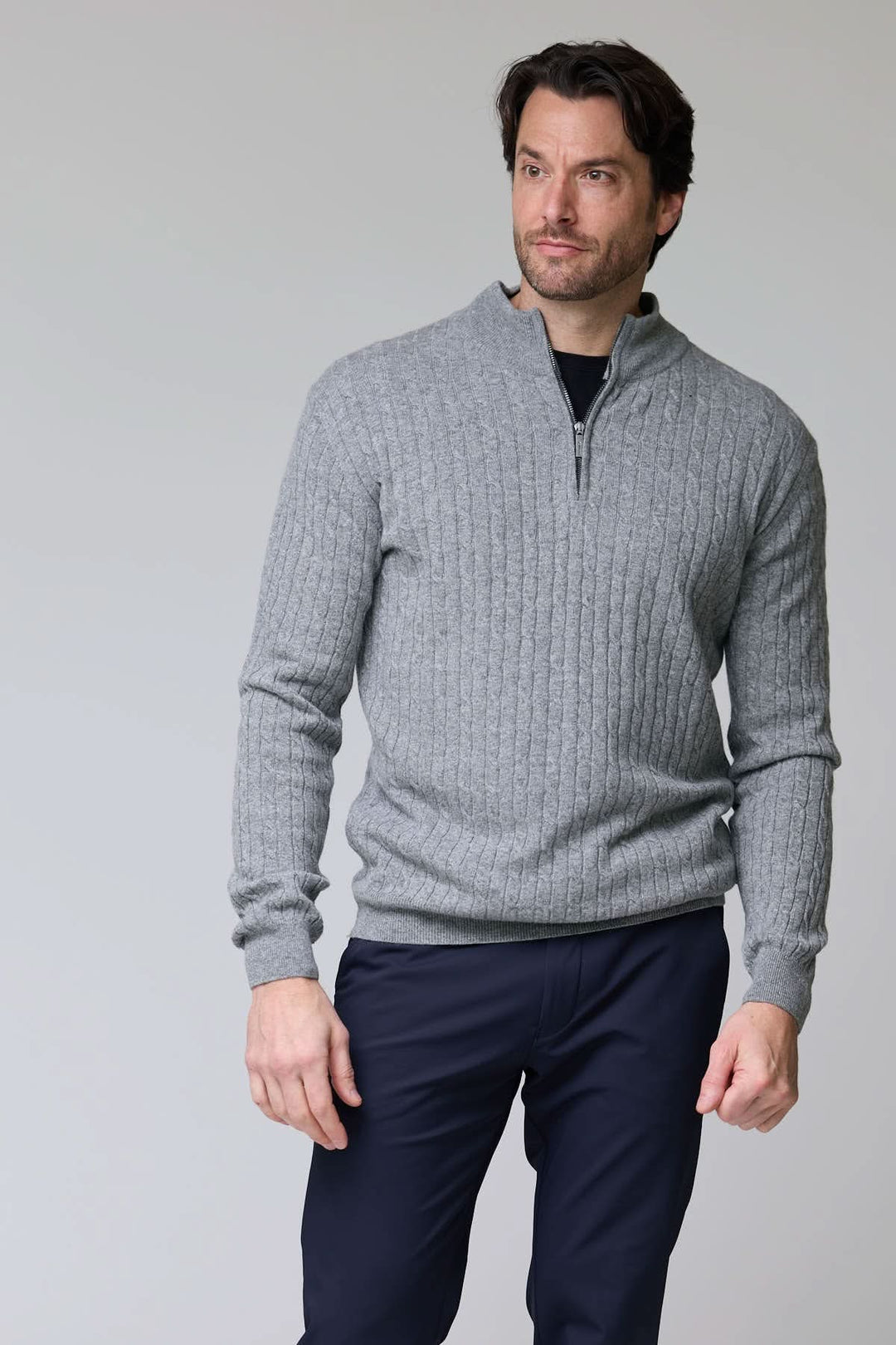 Homme portant un chandail à demi-glissière torsadé en laine gris, style élégant et décontracté.