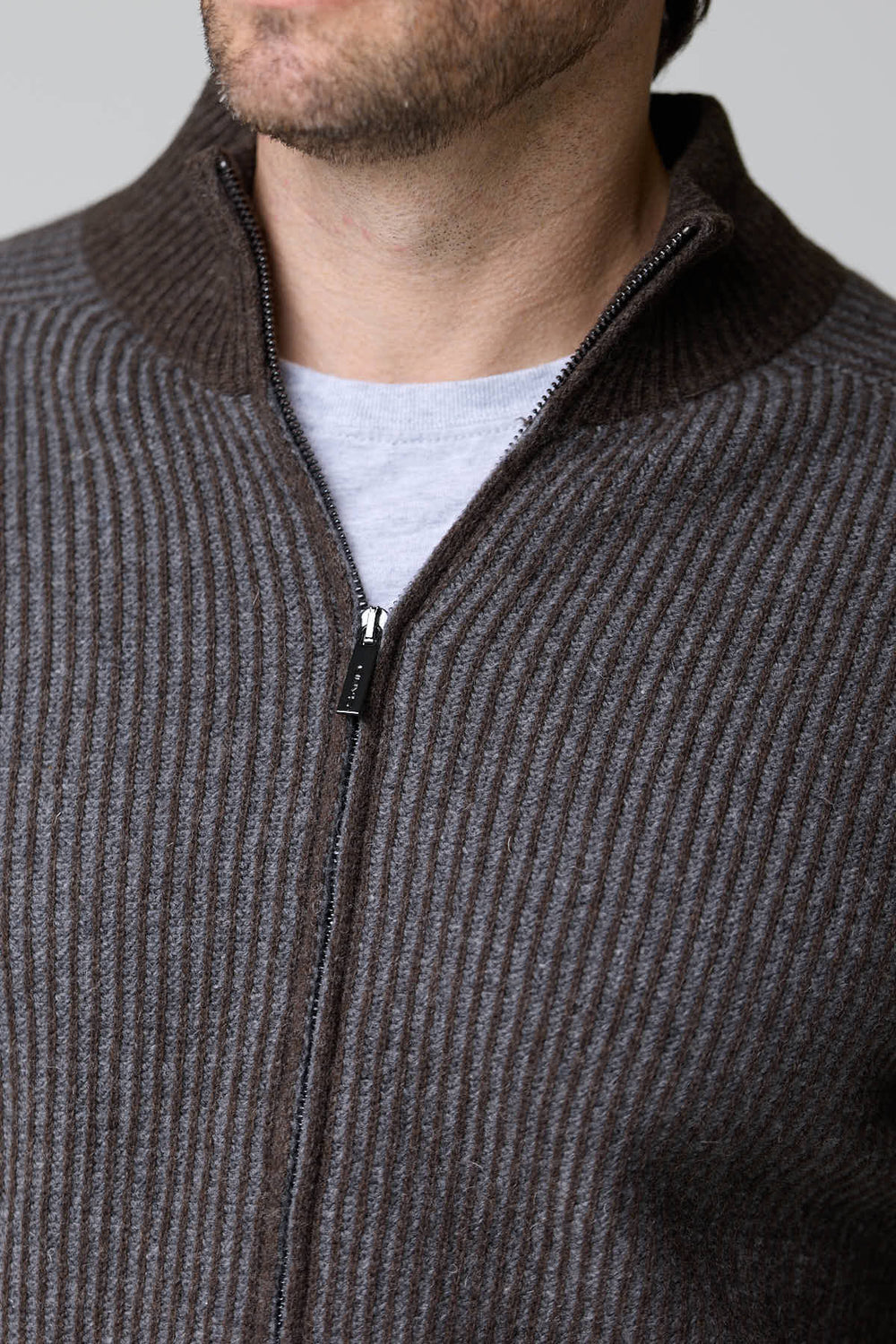 Homme portant un chandail à demi-glissière torsadé en laine mérinos, détails de motif torsadé et col zip.