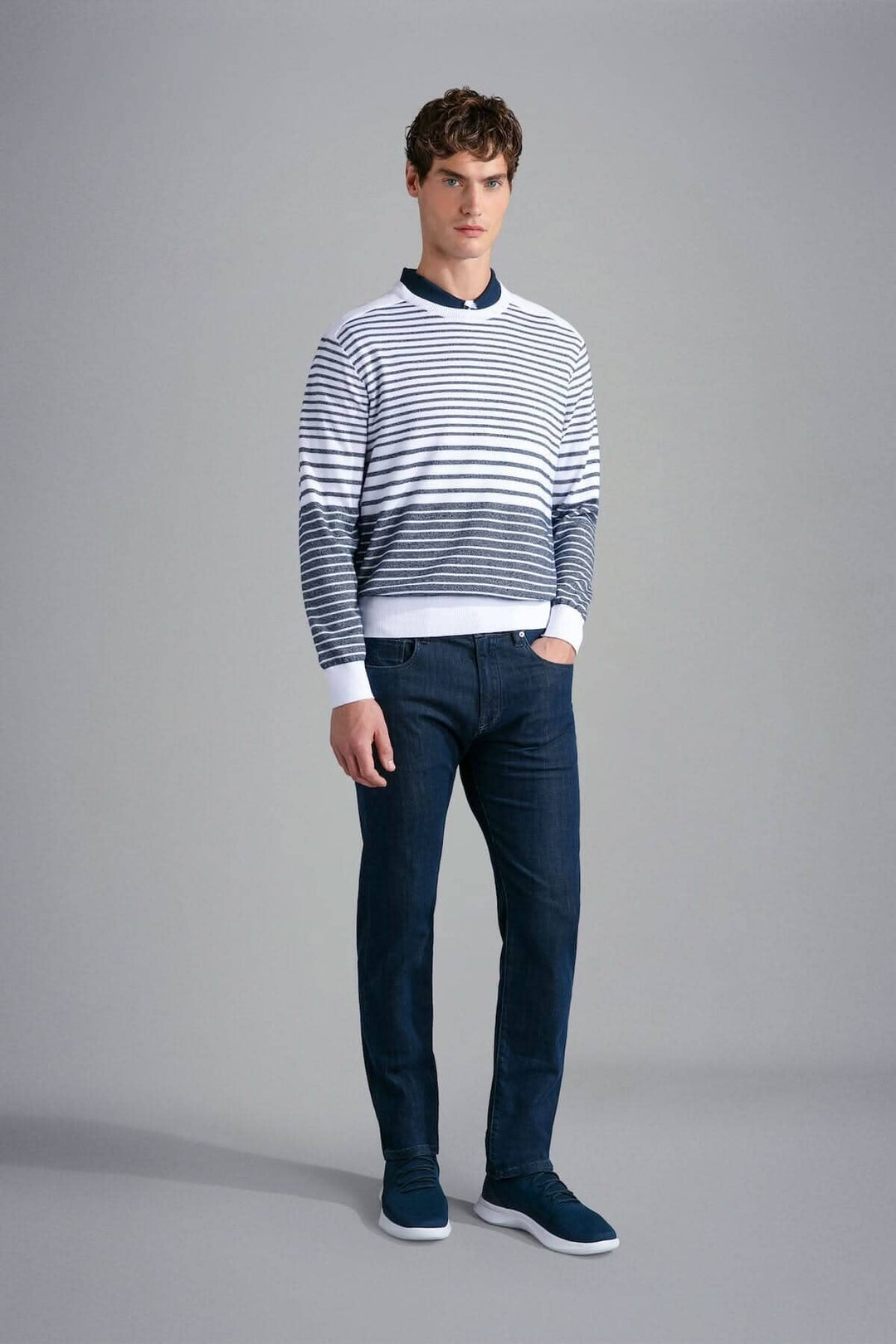 Homme portant un chandail rayé en coton Paul &amp; Shark Riviera, jeans foncés et baskets, style élégant.
