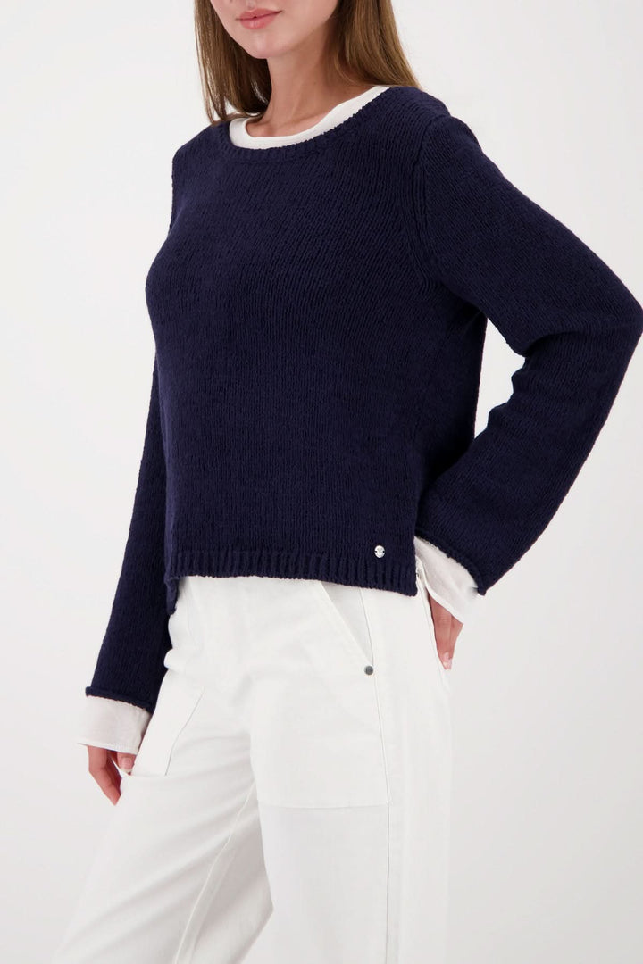 Femme portant un chandail à effet superposé col rond en maille avec finitions contrastantes, élégance contemporaine et polyvalente.