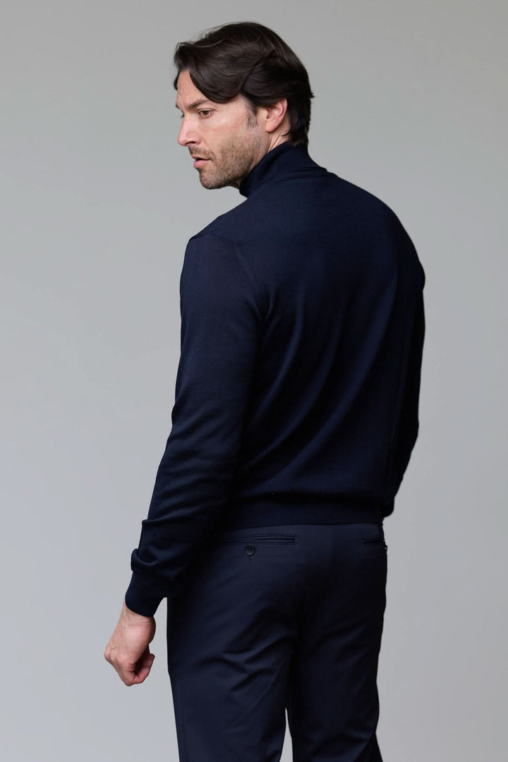 Homme portant un chandail en laine mérinos fine, élégant et sophistiqué, vue de dos, col rond, coupe droite, couleur bleu marine.