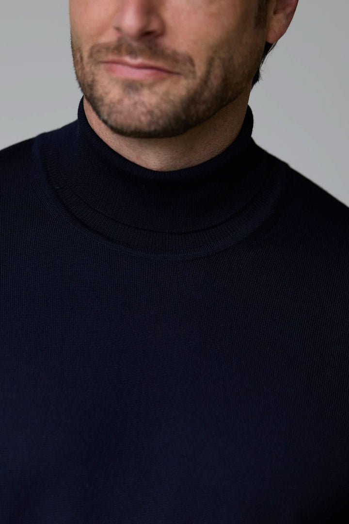 Homme portant un chandail en laine mérinos fine avec col rond tricoté, montrant le style net du vêtement.