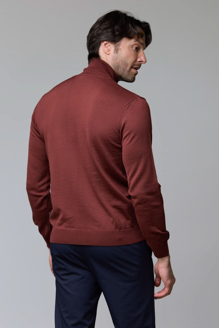 Homme portant un chandail en laine mérinos fine brun, col rond côtelé, coupe ajustée, style élégant et intemporel.
