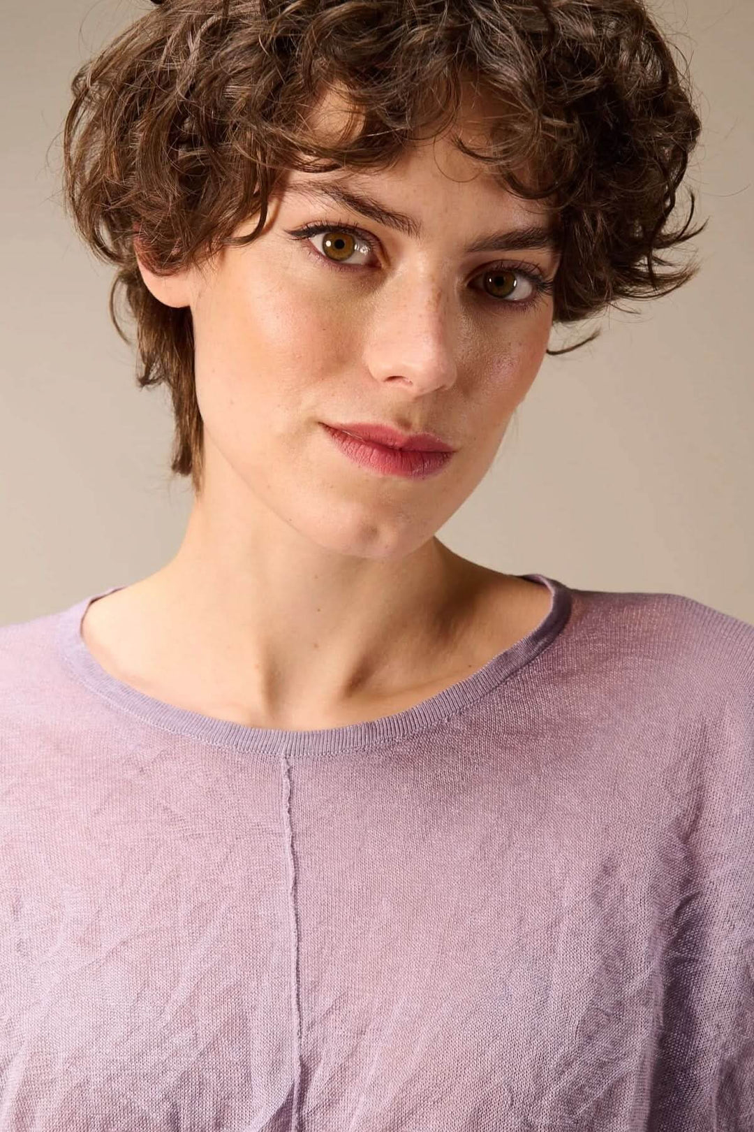 Chandail en maille fine léger avec texture froissée et encolure ronde, porté par une femme pour un look moderne et confortable.