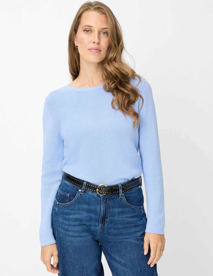 Femme portant le Chandail en maille texturée LESLEY bleu, manches longues, col bateau, pour un look moderne et décontracté.