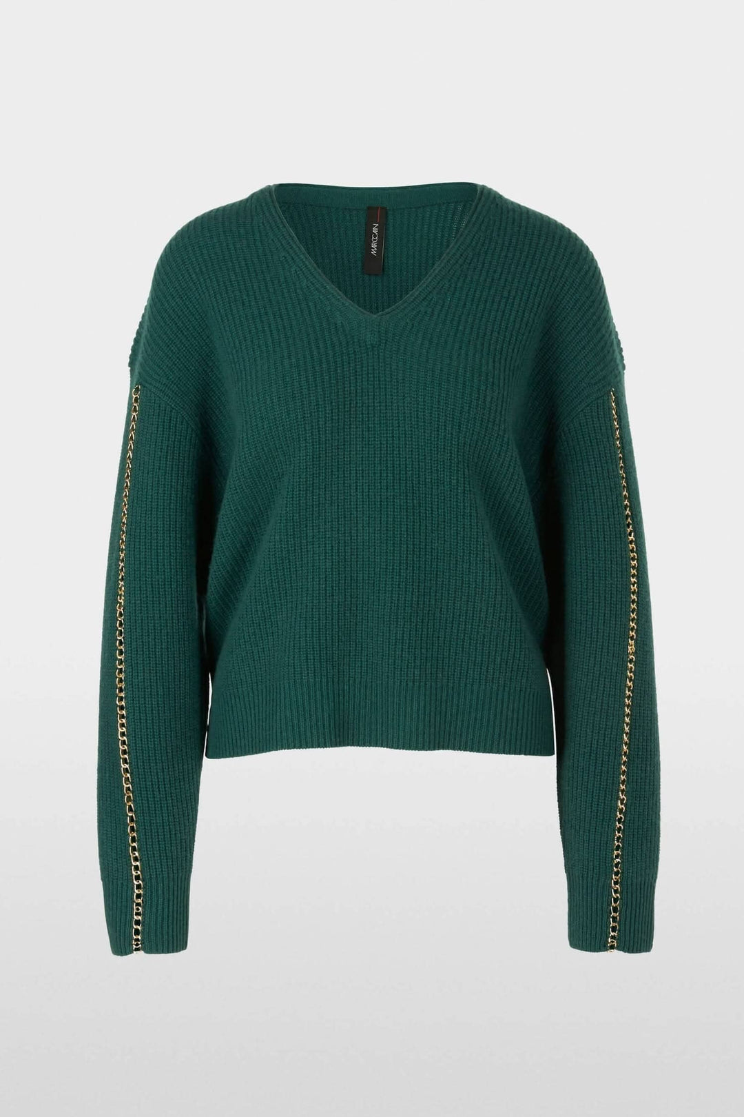 Pull en mailles vert émeraude avec col en V et chaîne en métal sur les manches, coupe large.