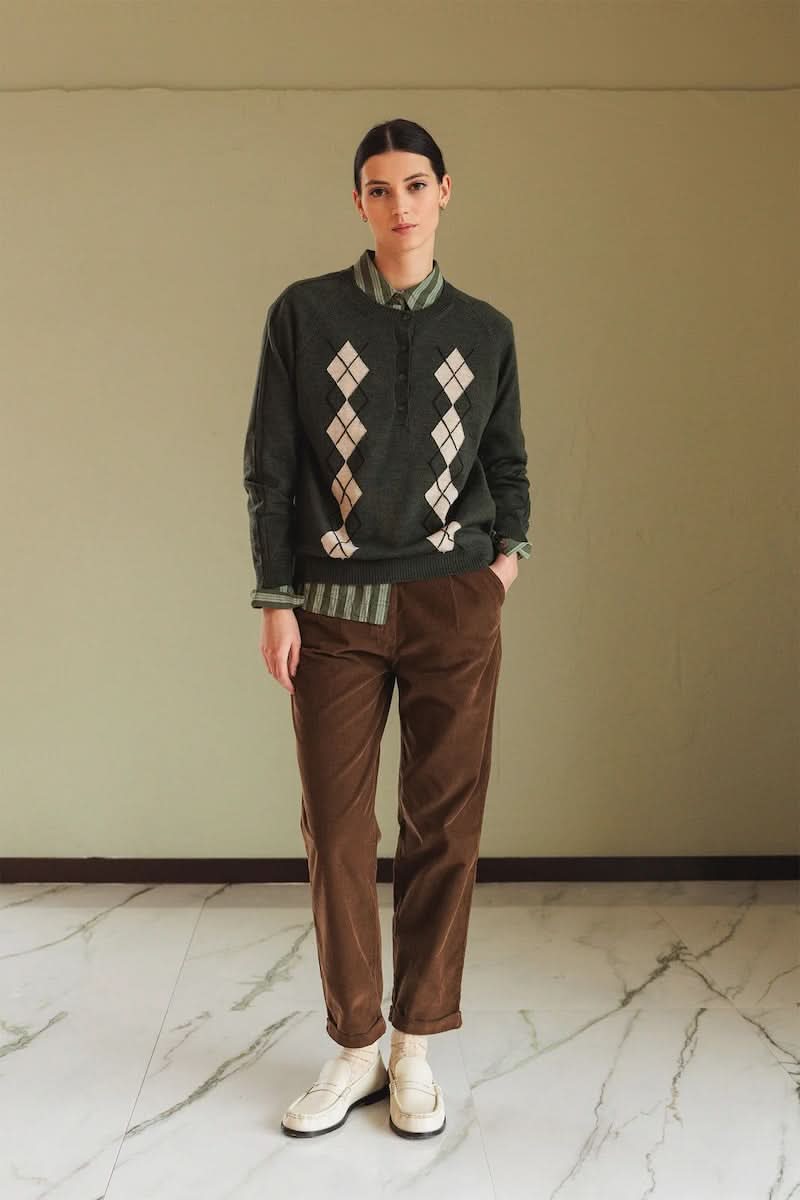 Chandail en mérinos à motif argyle porté par modèle dans un style preppy-chic, élégant et confortable.