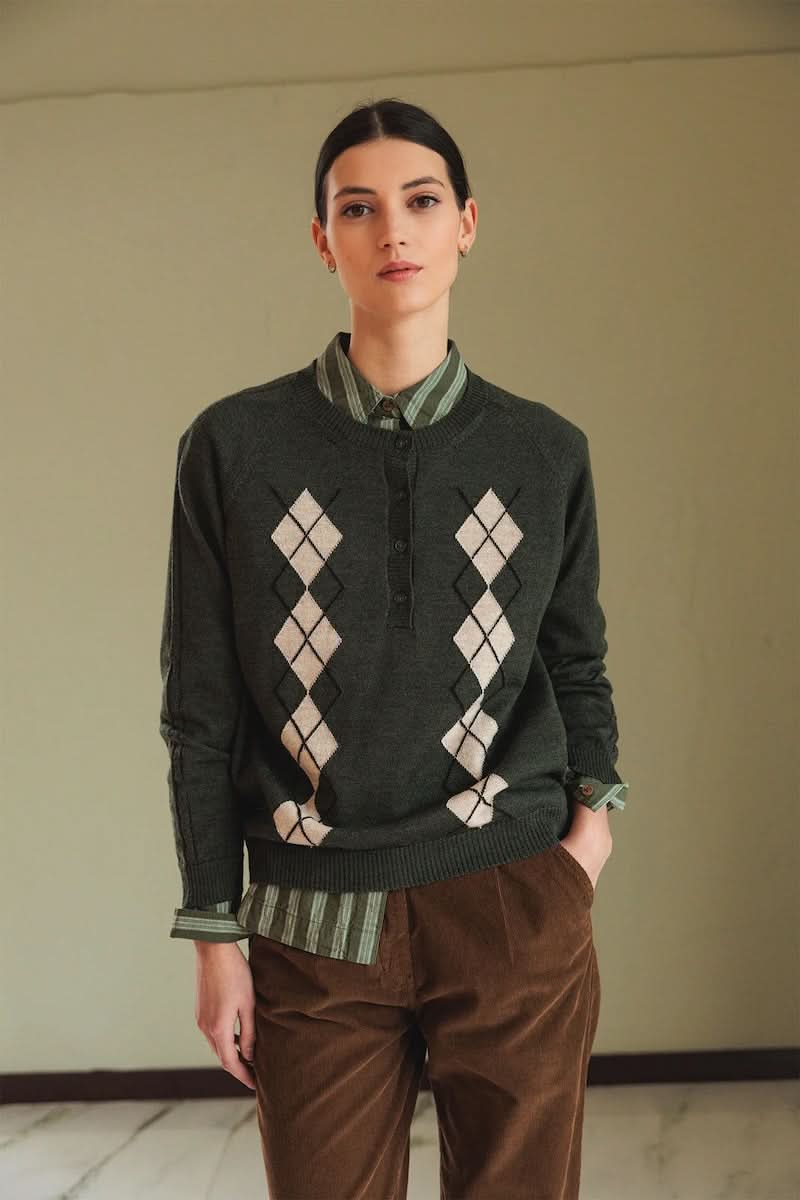 Chandail en mérinos à motif argyle, col rond côtelé, style preppy-chic avec chemise rayée et pantalon marron, look décontracté.