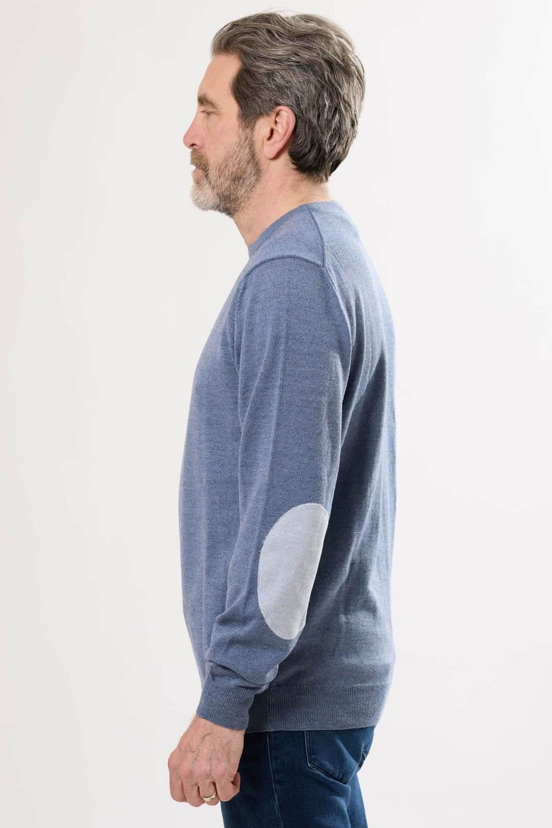 Homme portant un chandail en tricot bleu avec coudières contrastantes, profil latéral d&