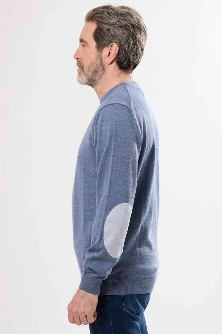 Homme portant un chandail en tricot bleu avec coudières contrastantes, profil latéral d&