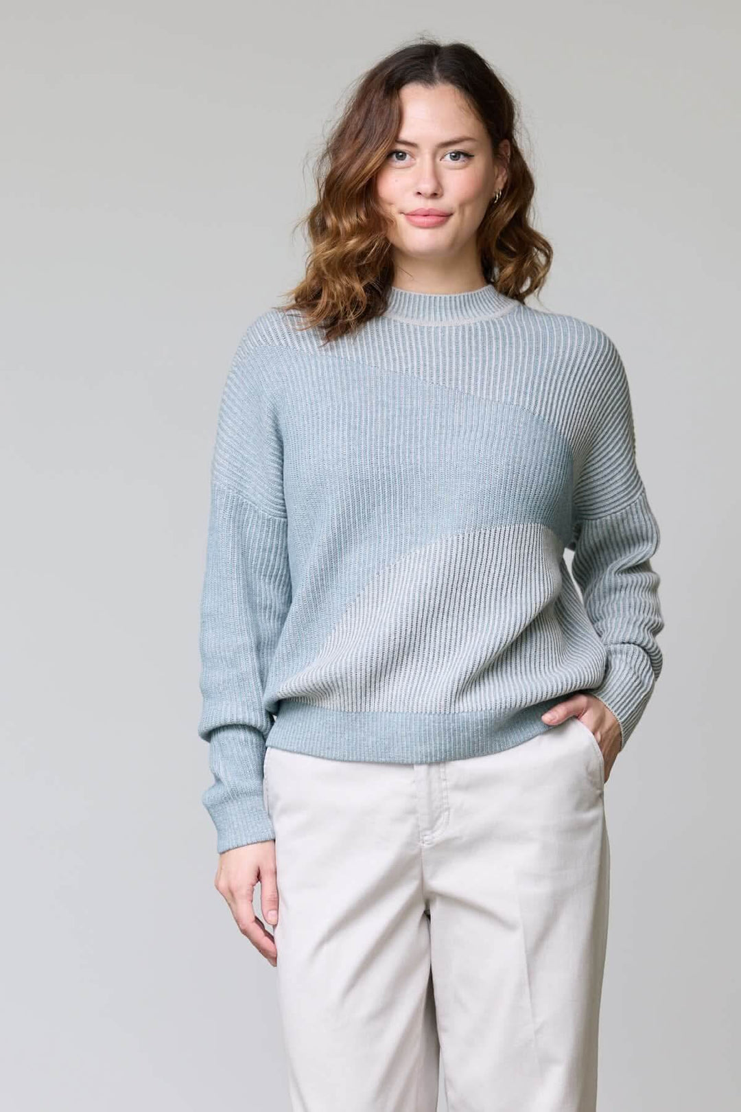 Woman wearing a chandail en tricot côtelé with ribbed texture, round neckline, and relaxed fit, demonstrating a casual, modern style.