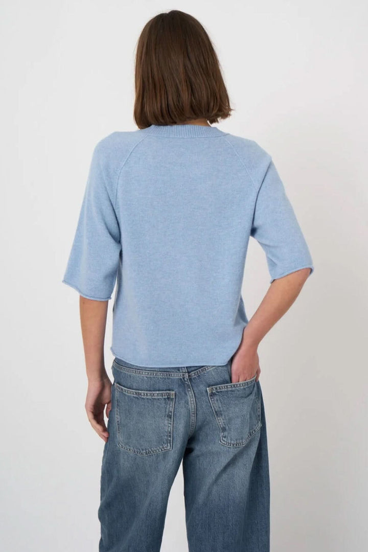 Chandail à manches courtes bleu clair, coupe droite, encolure ronde. Idéal pour un look décontracté et moderne. Vêtement polyvalent.