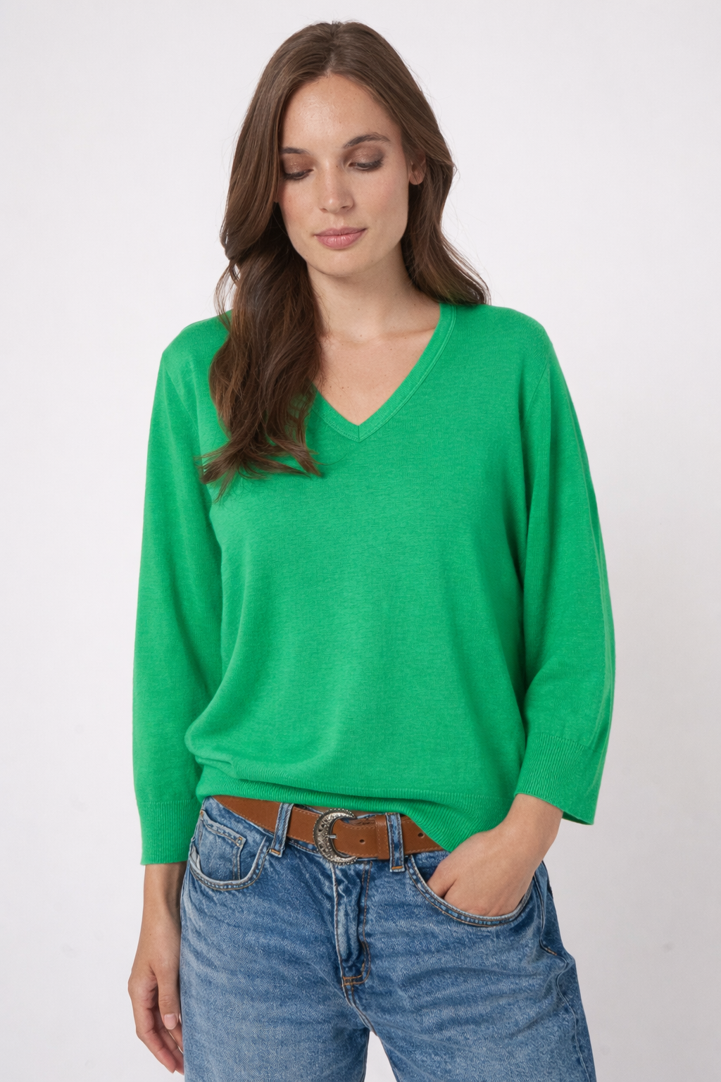Femme portant un chandail vert à manches longues, coupe décontractée, avec un jean.