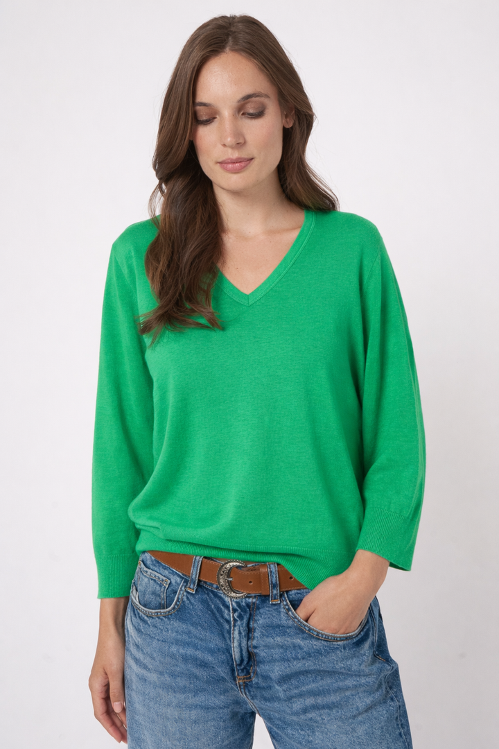 Femme portant un chandail vert à manches longues, coupe décontractée, avec un jean.