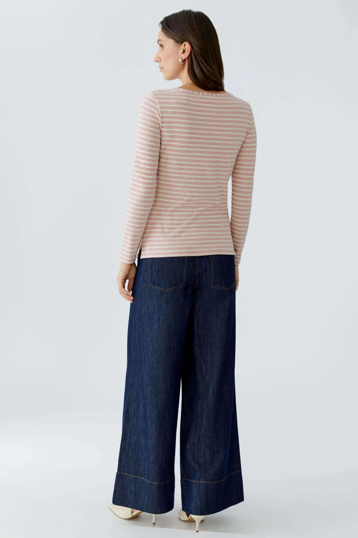 Femme portant un chandail à manches longues ligné, coupe droite, encolure ronde, confort quotidien avec jeans larges, dos visible.