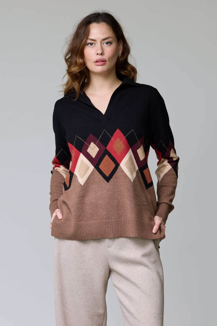 Femme portant un chandail à motif losanges multicolores avec col ouvert et manches longues, style décontracté.