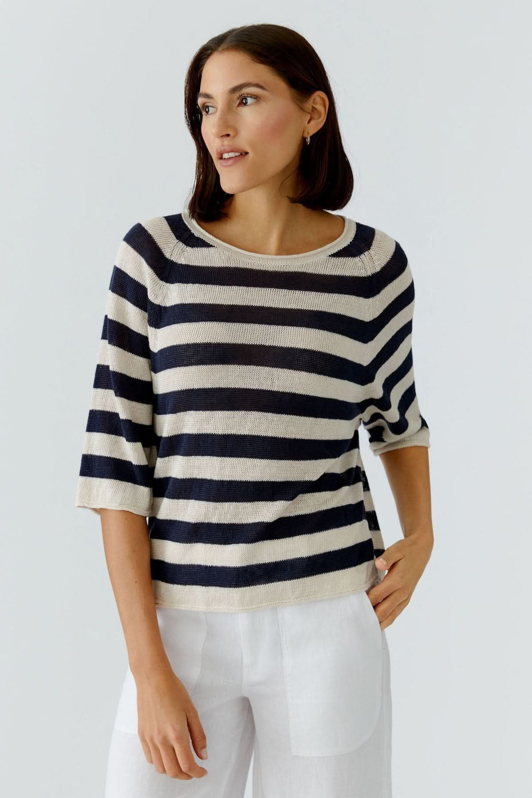 Modèle portant un chandail à rayures texturées manches trois-quarts avec encolure ronde, coupe droite et élégante. Décontracté et chic.