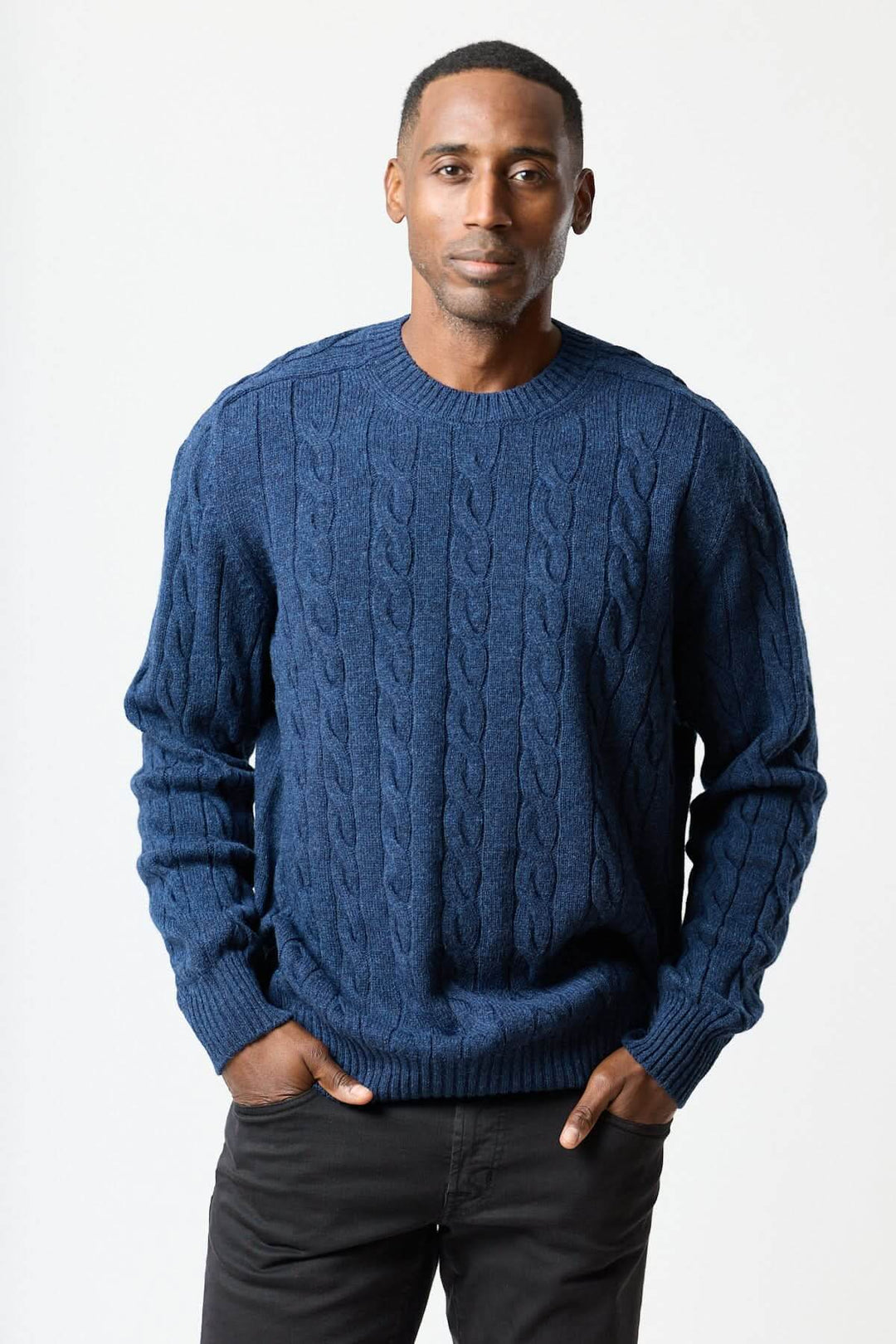 Homme portant un chandail torsadé col rond bleu, texture en maille câblée, confort quotidien.