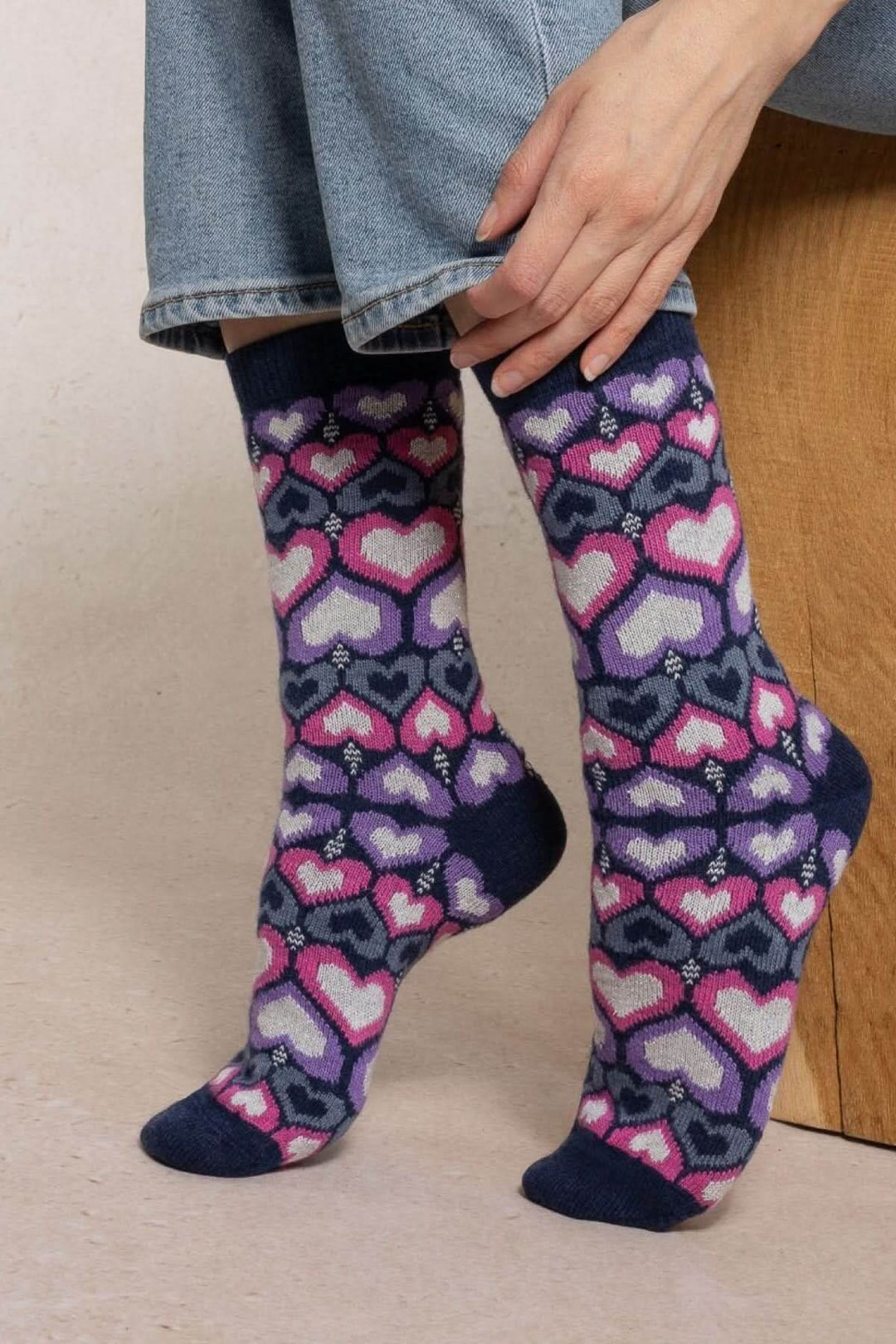 Chaussettes en tricot à motif avec cœurs colorés portées avec un jean, offrant confort et chaleur.