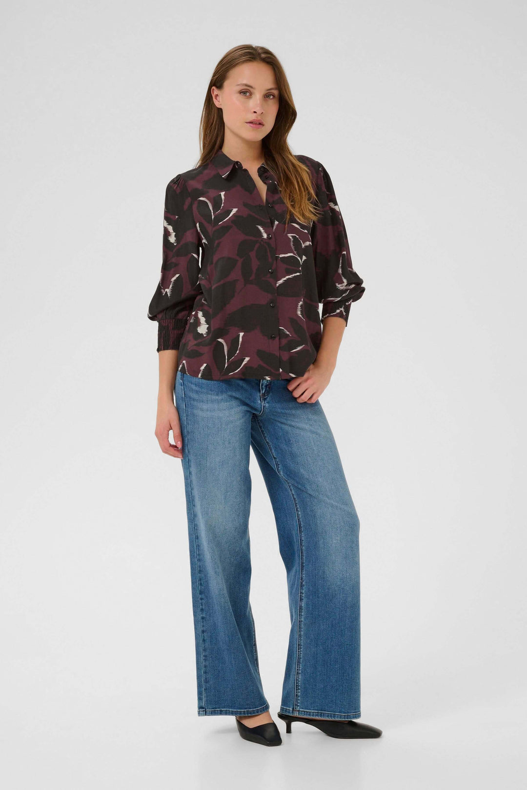 Femme portant la Chemise Mille imprimée avec un jean, montrant un look moderne et élégant.