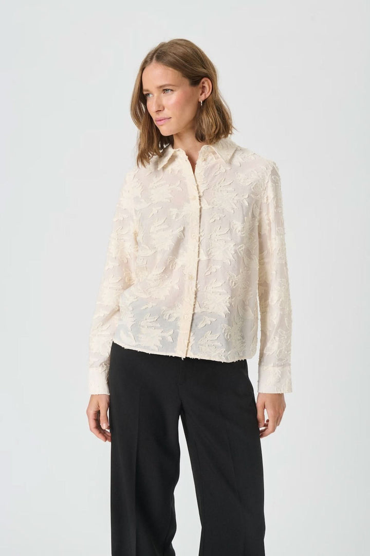 Chemise Vilya à relief floral ton sur ton en viscose semi-transparente, manches longues et col classique, élégante et confortable.